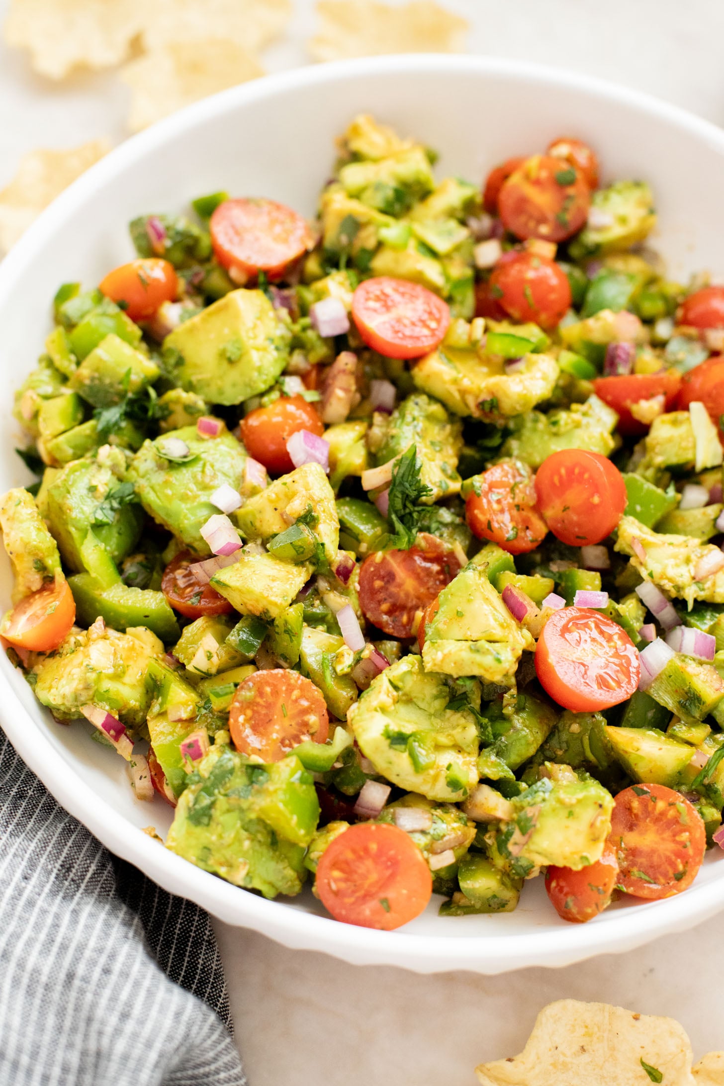 This Avocado Tomato Salad is a hearty side dish or appetizer. Best served with tortilla chips for the perfect bite | ThisSavoryVegan.com