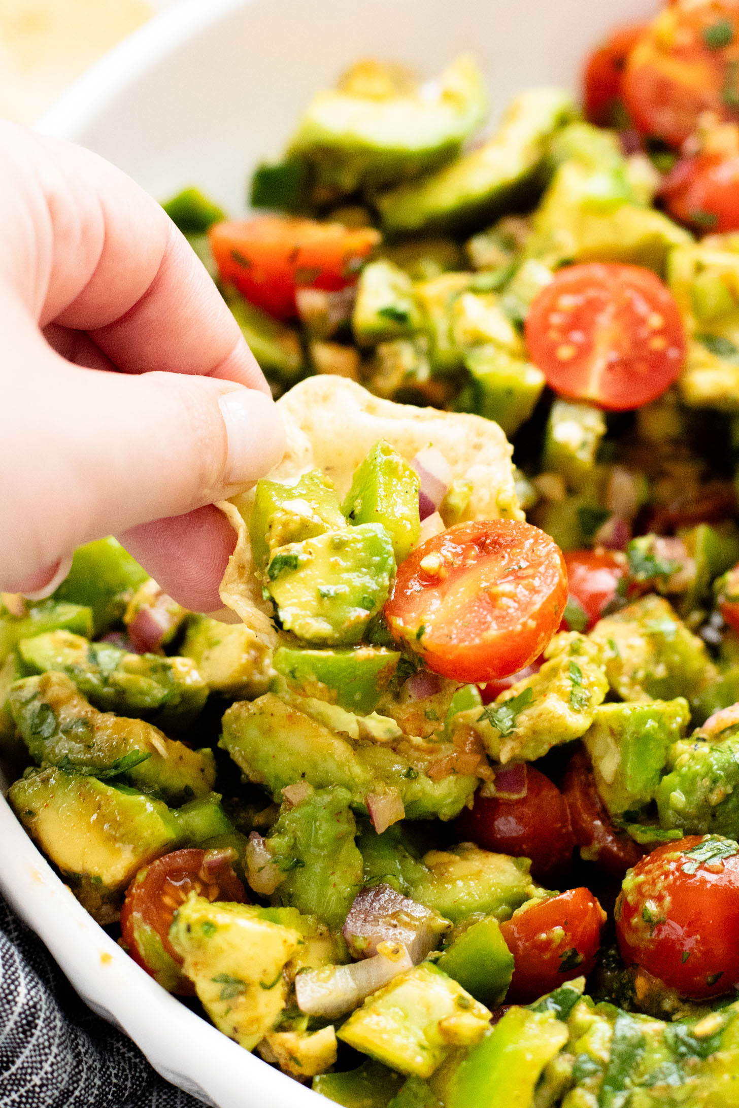 This Avocado Tomato Salad is a hearty side dish or appetizer. Best served with tortilla chips for the perfect bite | ThisSavoryVegan.com