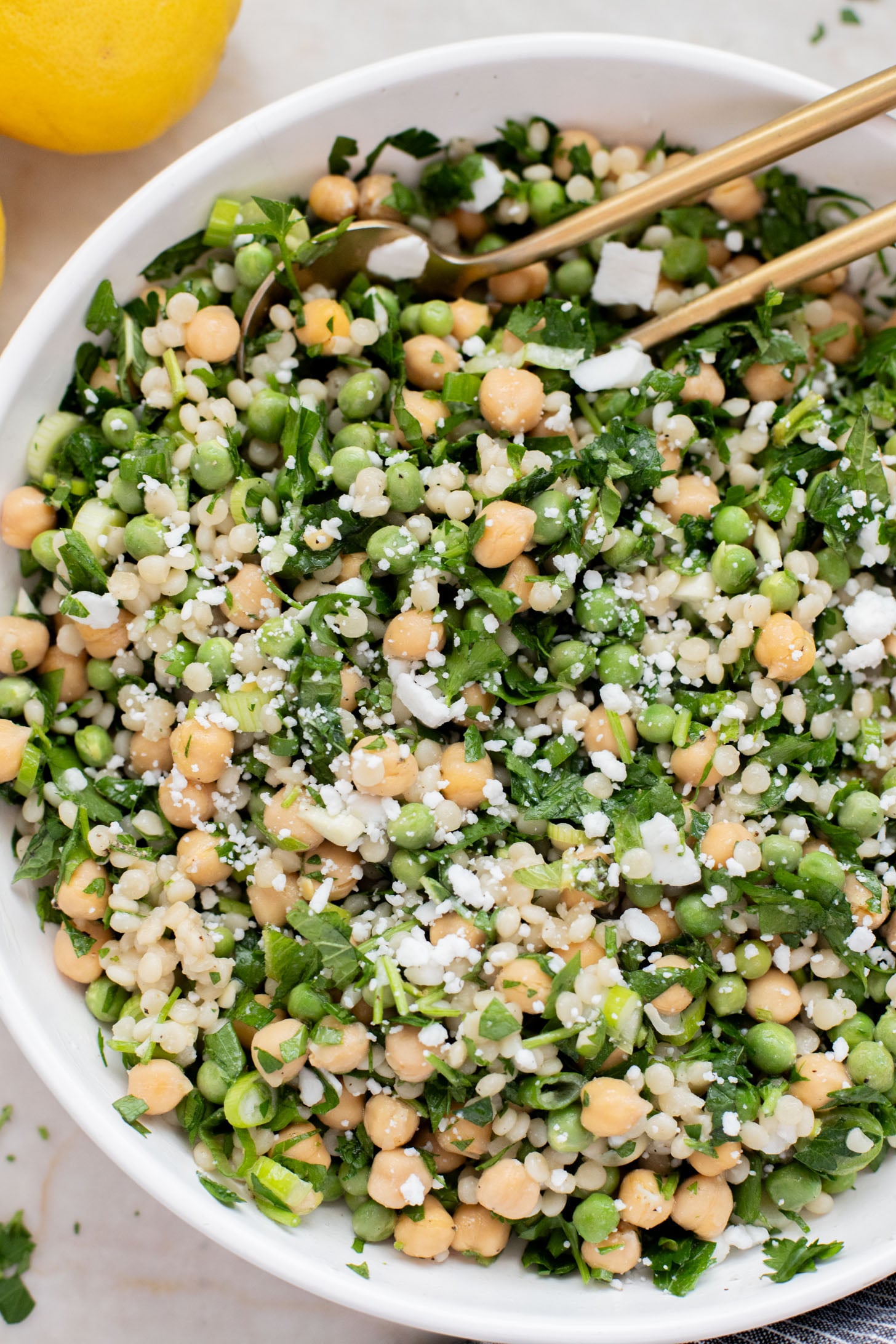 This Spring Pea Couscous Salad is filled with fresh herbs, English peas, chickpeas, pearl couscous and a delicious lemon dressing | ThisSavoryVegan.com