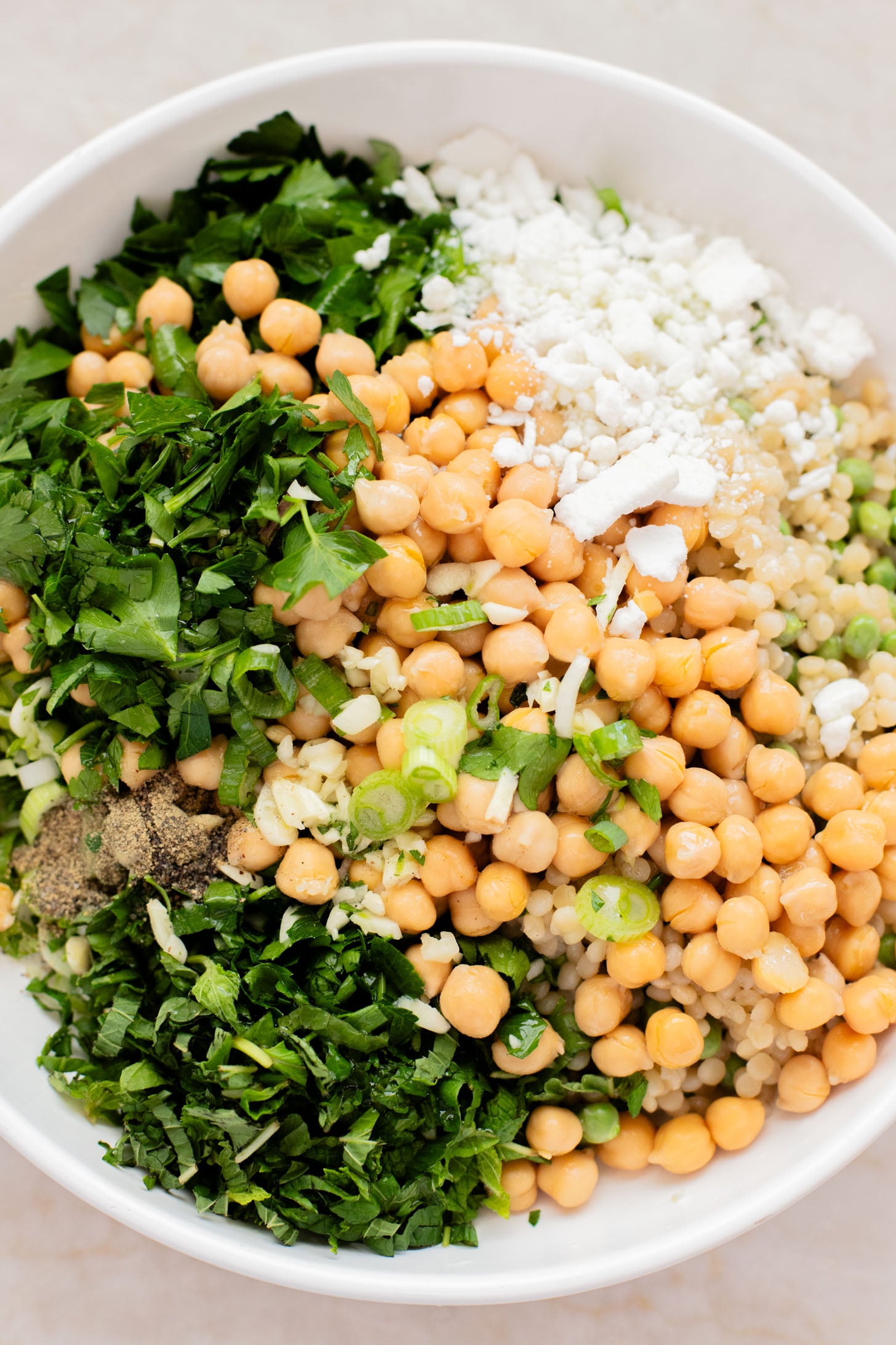 This Spring Pea Couscous Salad is filled with fresh herbs, English peas, chickpeas, pearl couscous and a delicious lemon dressing | ThisSavoryVegan.com