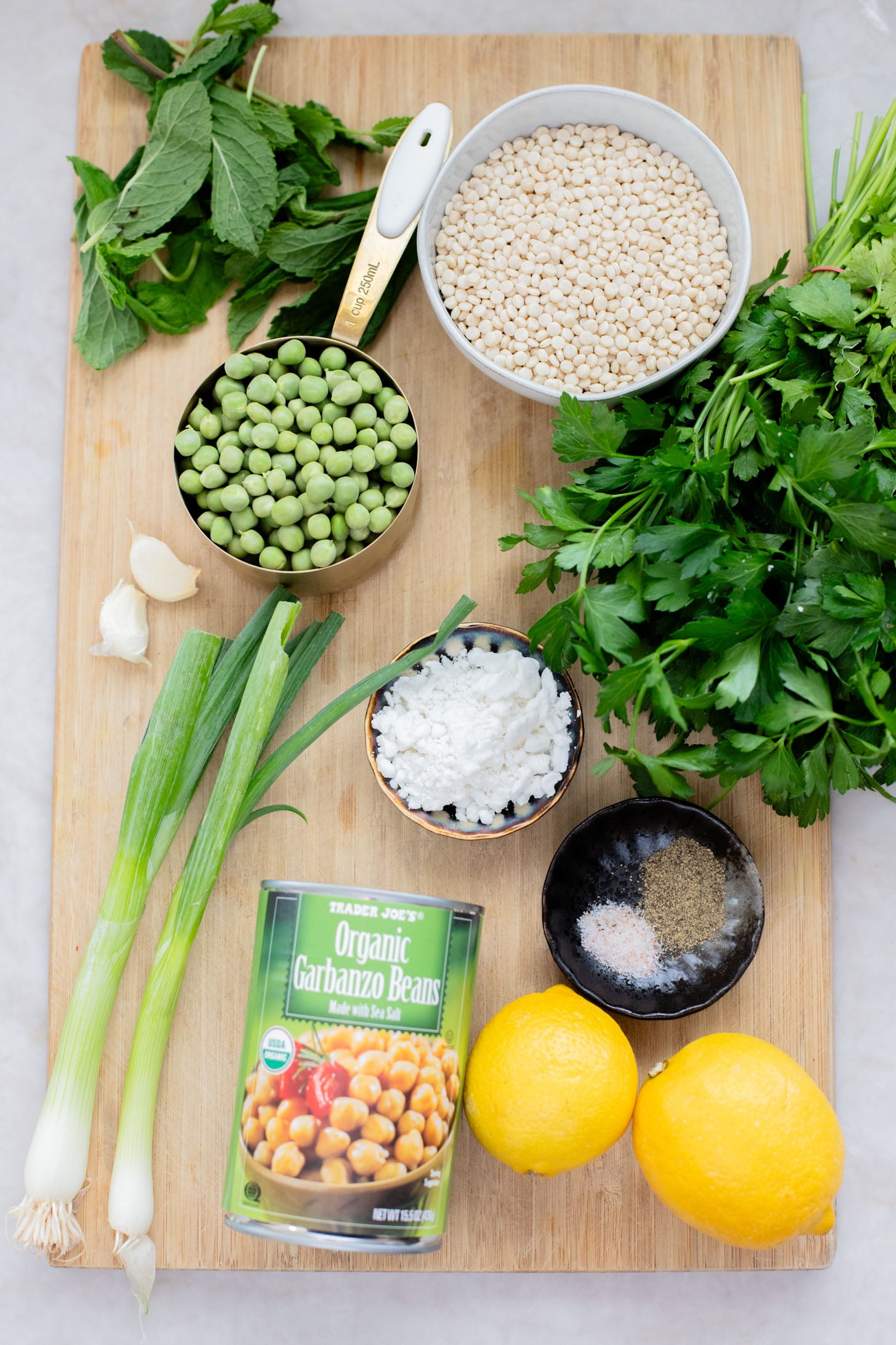 This Spring Pea Couscous Salad is filled with fresh herbs, English peas, chickpeas, pearl couscous and a delicious lemon dressing | ThisSavoryVegan.com