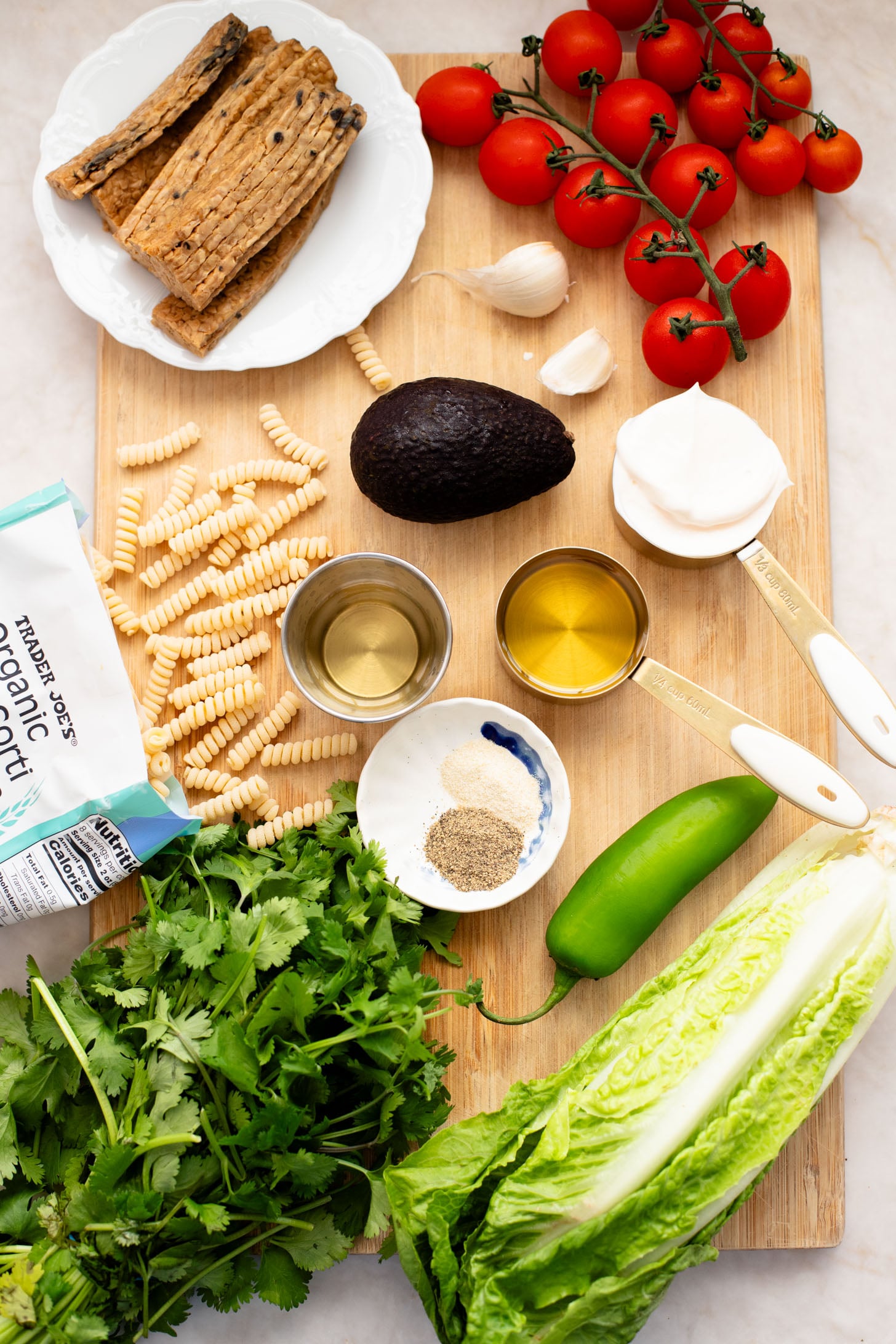 This TTLA Pasta Salad is the ultimate vegan take on a BLT pasta salad. It has a creamy avocado dressing, crispy tempeh and fresh veggies | ThisSavoryVegan.com