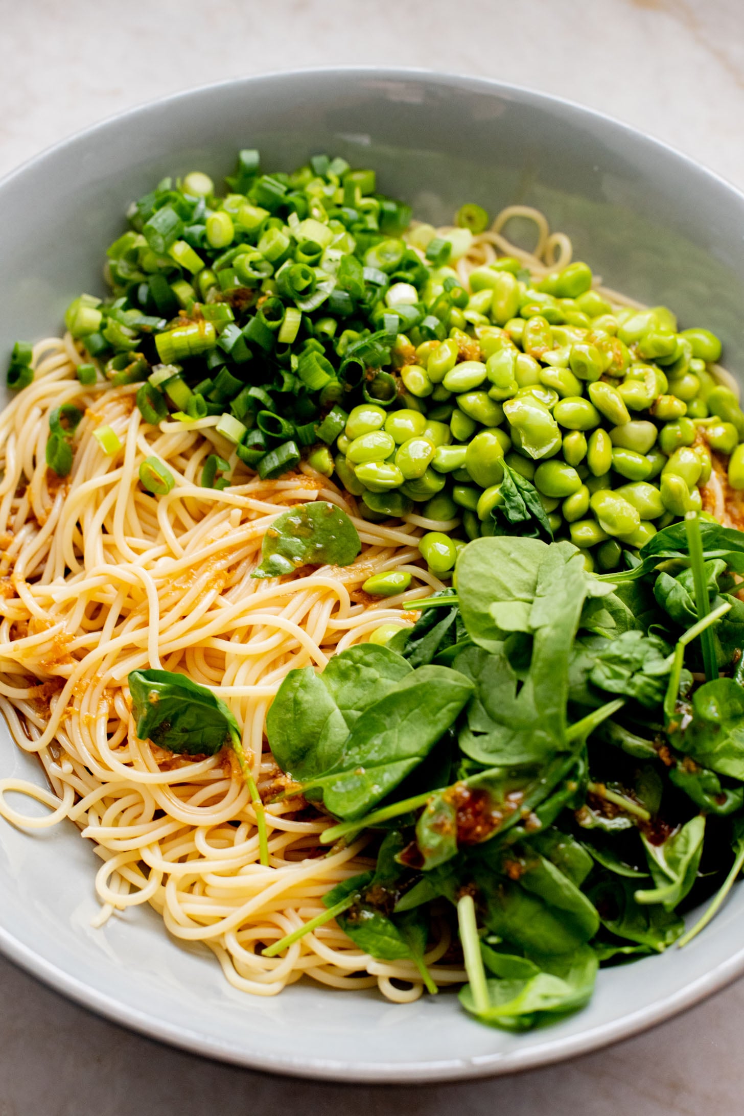 This Cold Edamame Noodle Salad is the perfect dinner when you want something fresh & comforting. Topped with chili crisp for a little heat & packed with plant protein | ThisSavoryVegan.com