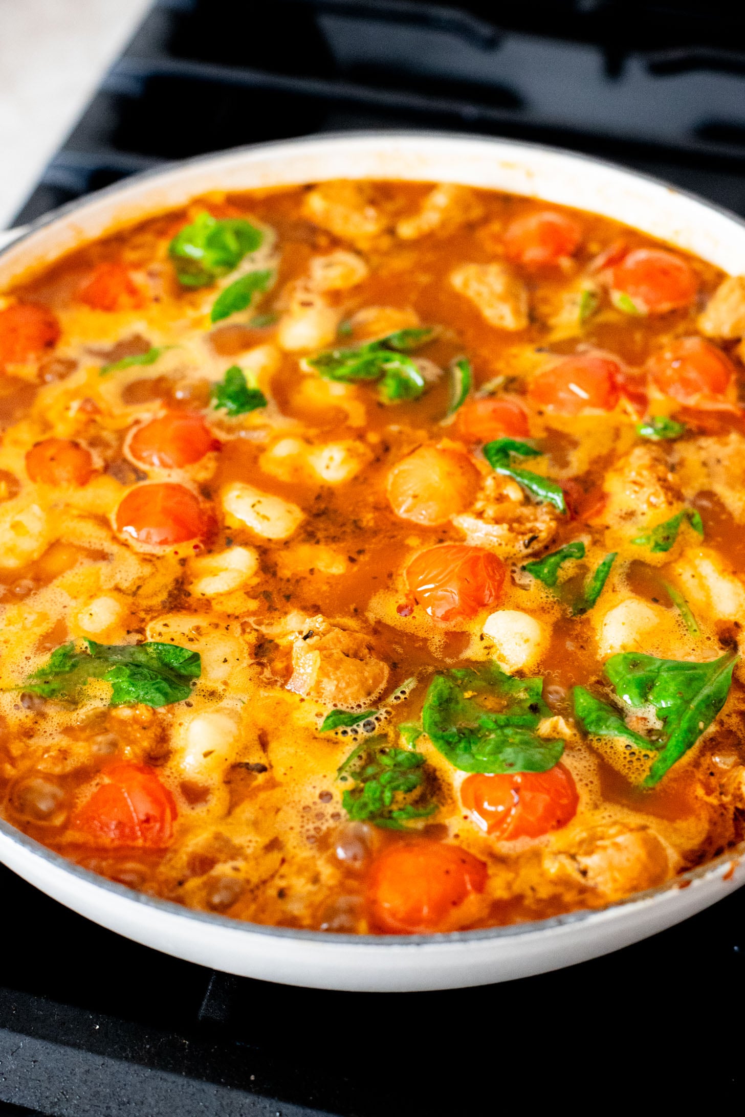 This Soupy Tomato Basil Gnocchi Bake is the perfect soup, that isn't a soup. Gnocchi is baked in a tomato broth and topped with vegan cheese | ThisSavoryVegan.com