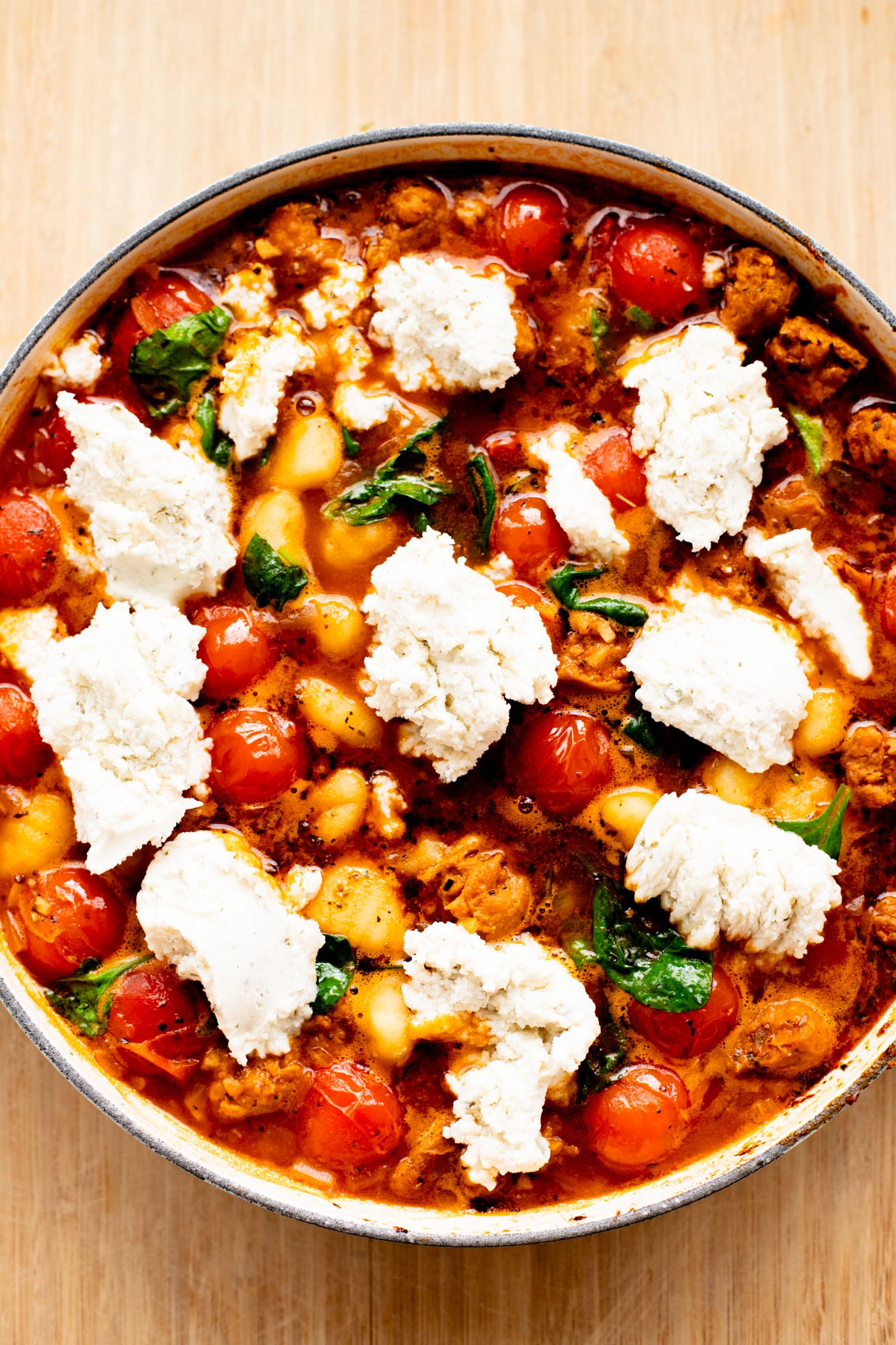 This Soupy Tomato Basil Gnocchi Bake is the perfect soup, that isn't a soup. Gnocchi is baked in a tomato broth and topped with vegan cheese | ThisSavoryVegan.com
