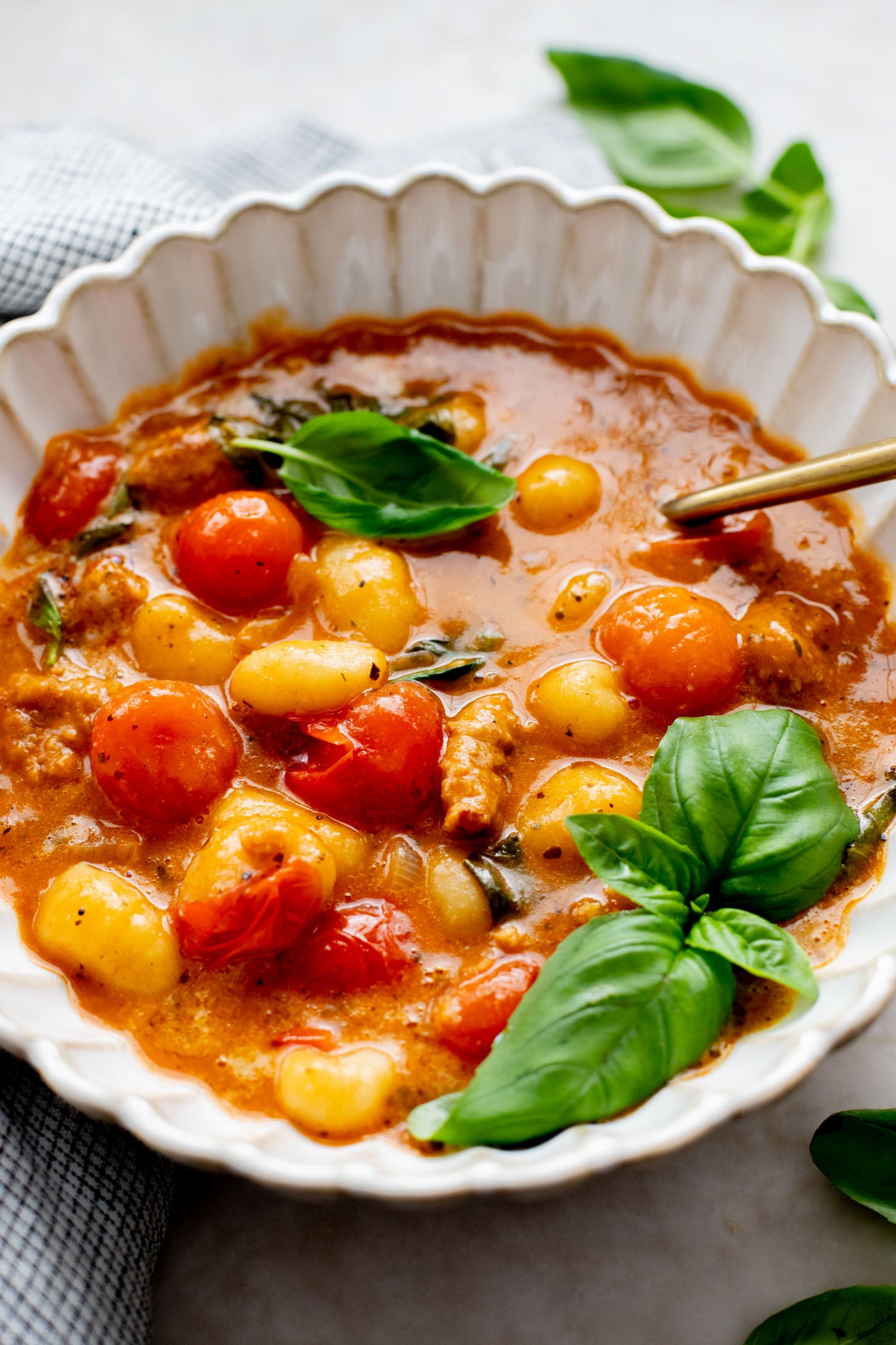 This Soupy Tomato Basil Gnocchi Bake is the perfect soup, that isn't a soup. Gnocchi is baked in a tomato broth and topped with vegan cheese | ThisSavoryVegan.com