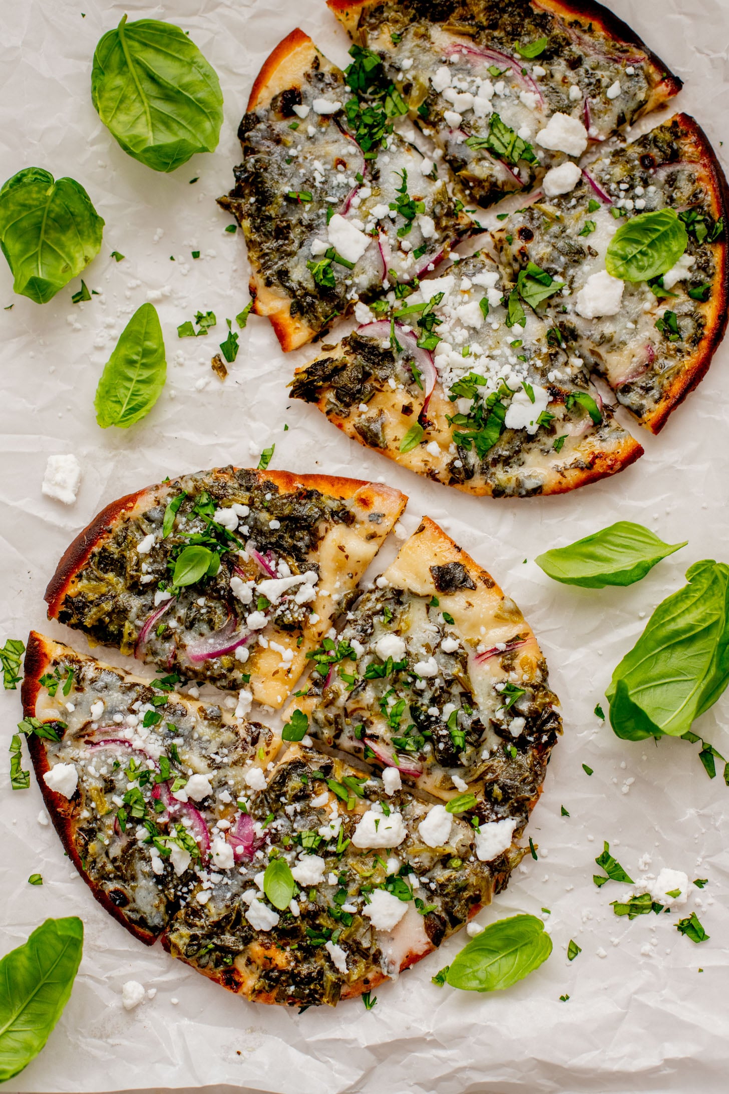 These Spinach & Feta Pita Pizzas are the perfect quick vegan dinner. Made with just a few ingredients and ready in less than 30 minutes. Kid-friendly too | ThisSavoryVegan.com