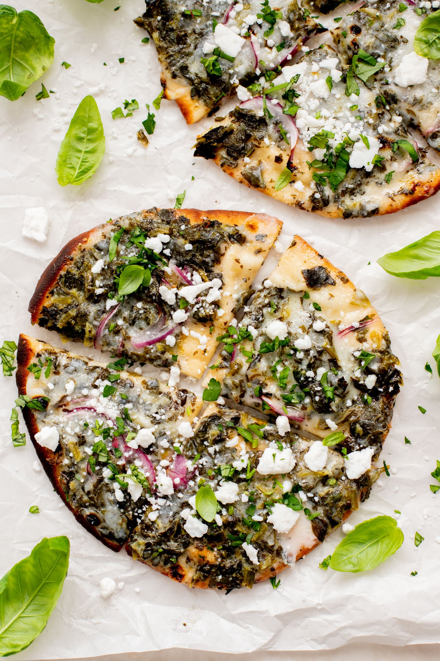 These Spinach & Feta Pita Pizzas are the perfect quick vegan dinner. Made with just a few ingredients and ready in less than 30 minutes. Kid-friendly too | ThisSavoryVegan.com
