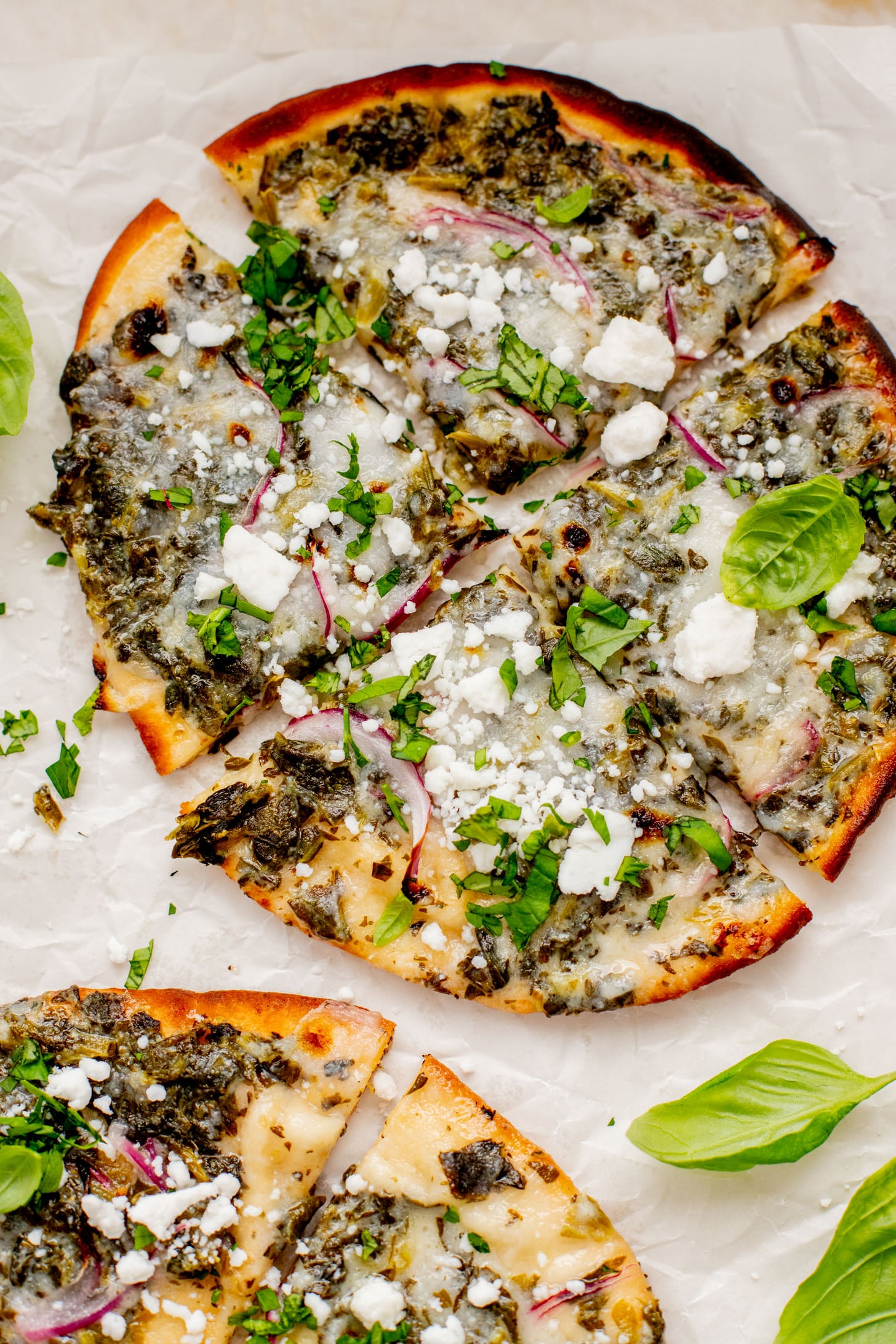 These Spinach & Feta Pita Pizzas are the perfect quick vegan dinner. Made with just a few ingredients and ready in less than 30 minutes. Kid-friendly too | ThisSavoryVegan.com