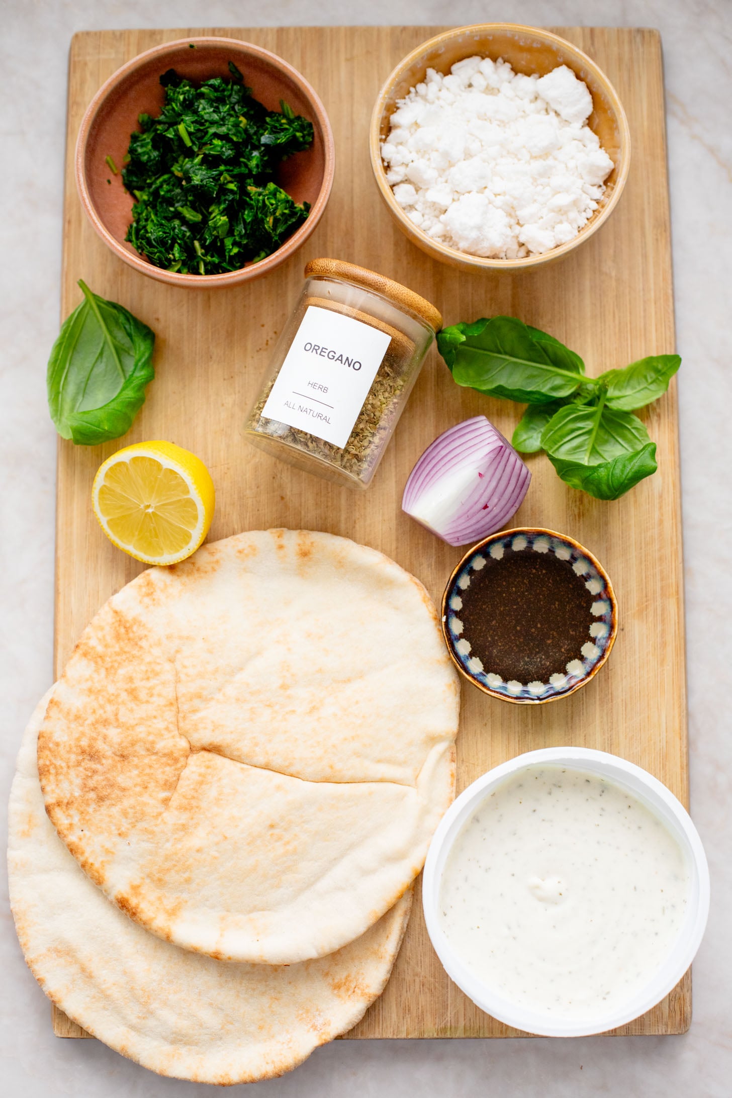 These Spinach & Feta Pita Pizzas are the perfect quick vegan dinner. Made with just a few ingredients and ready in less than 30 minutes. Kid-friendly too | ThisSavoryVegan.com