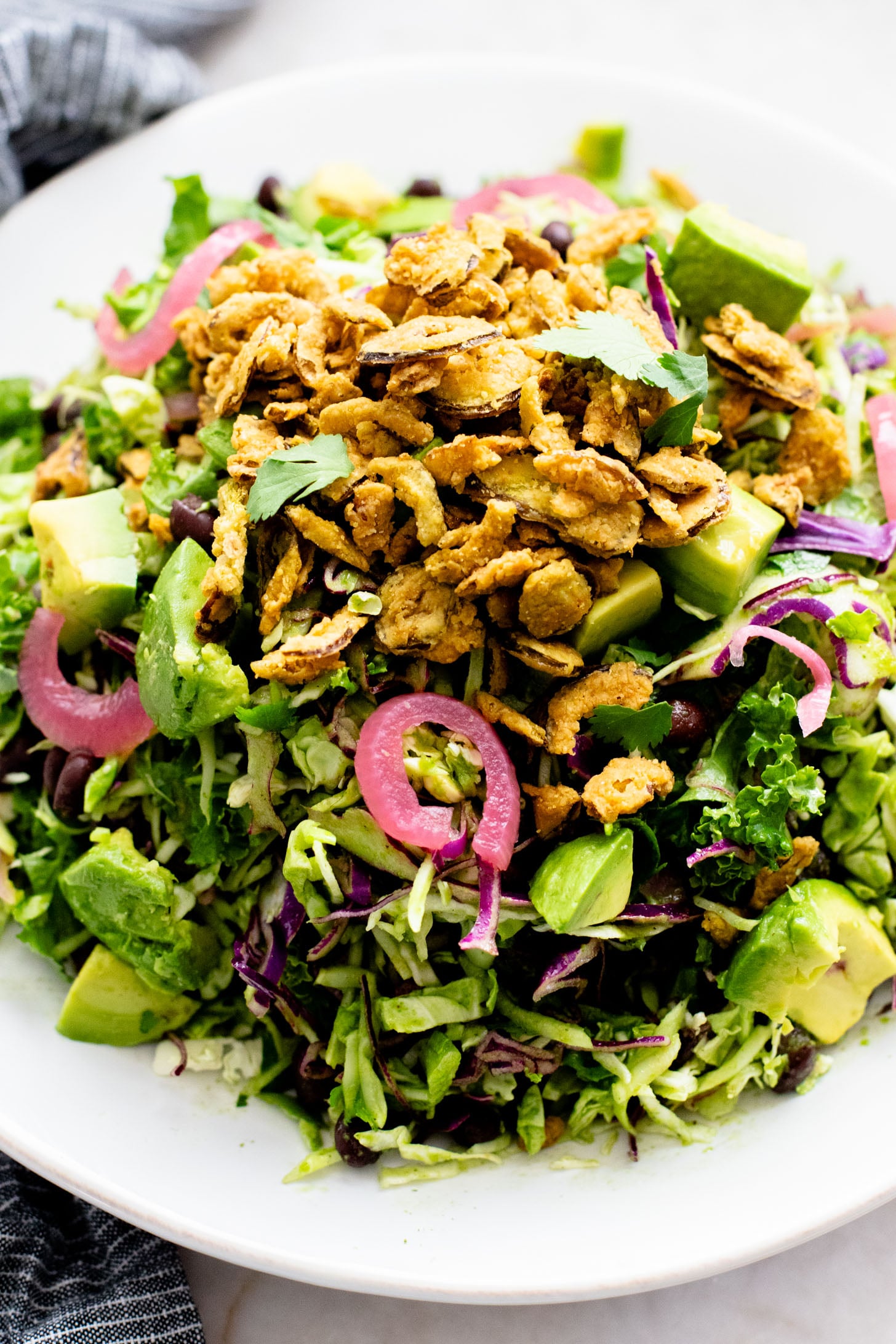 This Trader Joe's Black Bean Crunch Salad is a flavor bomb. Crisp kale slaw, black beans, crunchy jalapeños, pickled onions & a delicious cilantro lime dressing | ThisSavoryVegan.com