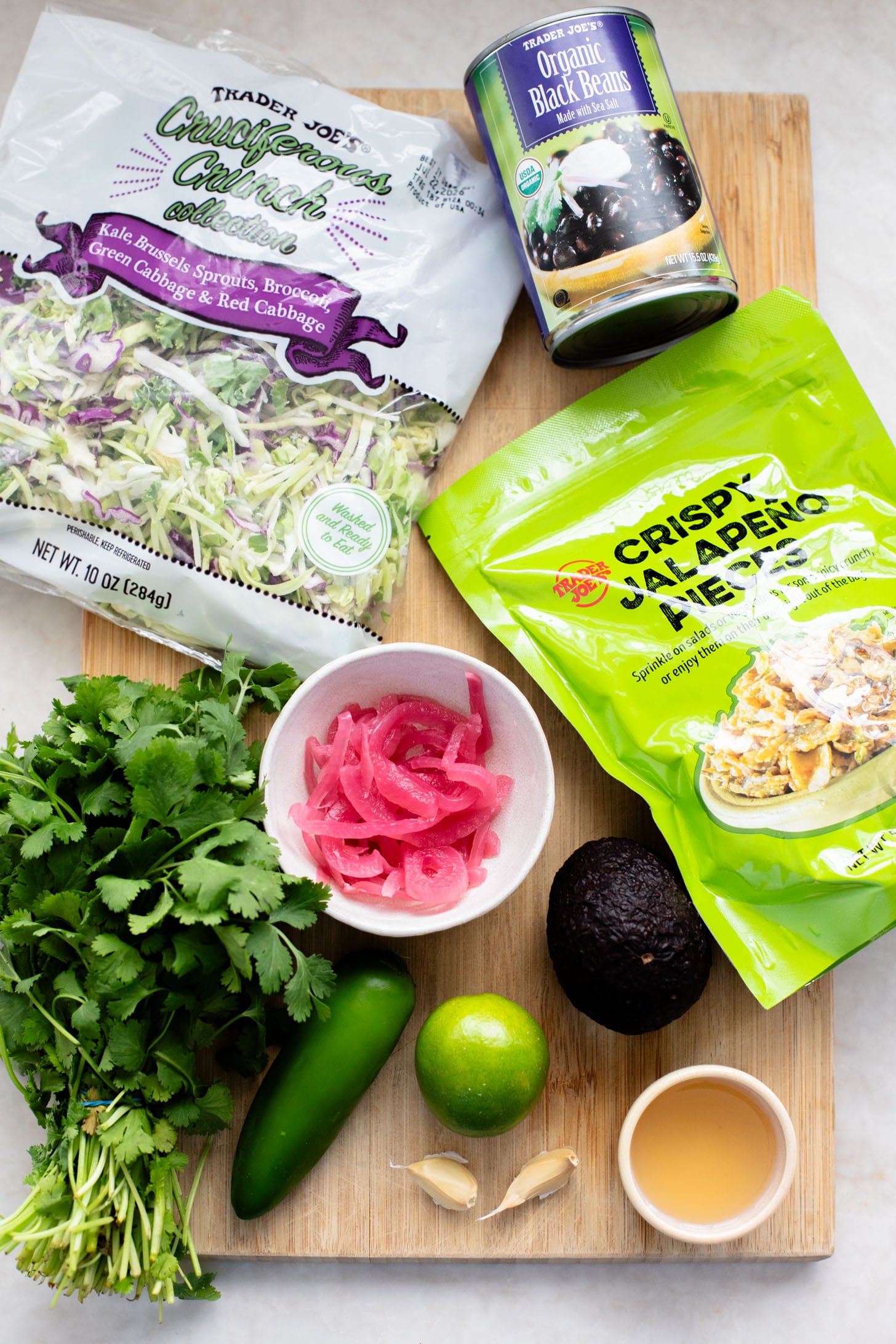 This Trader Joe's Black Bean Crunch Salad is a flavor bomb. Crisp kale slaw, black beans, crunchy jalapeños, pickled onions & a delicious cilantro lime dressing | ThisSavoryVegan.com
