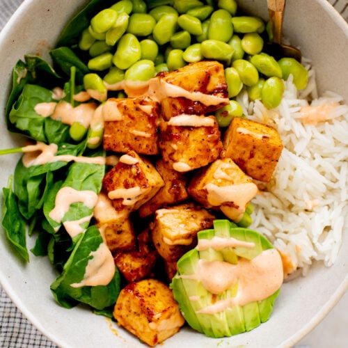 These Sweet Chili Tofu Bowls are loaded with crispy tofu, edamame, rice, avocado, greens & a spicy vegan mayo | ThisSavoryVegan.com