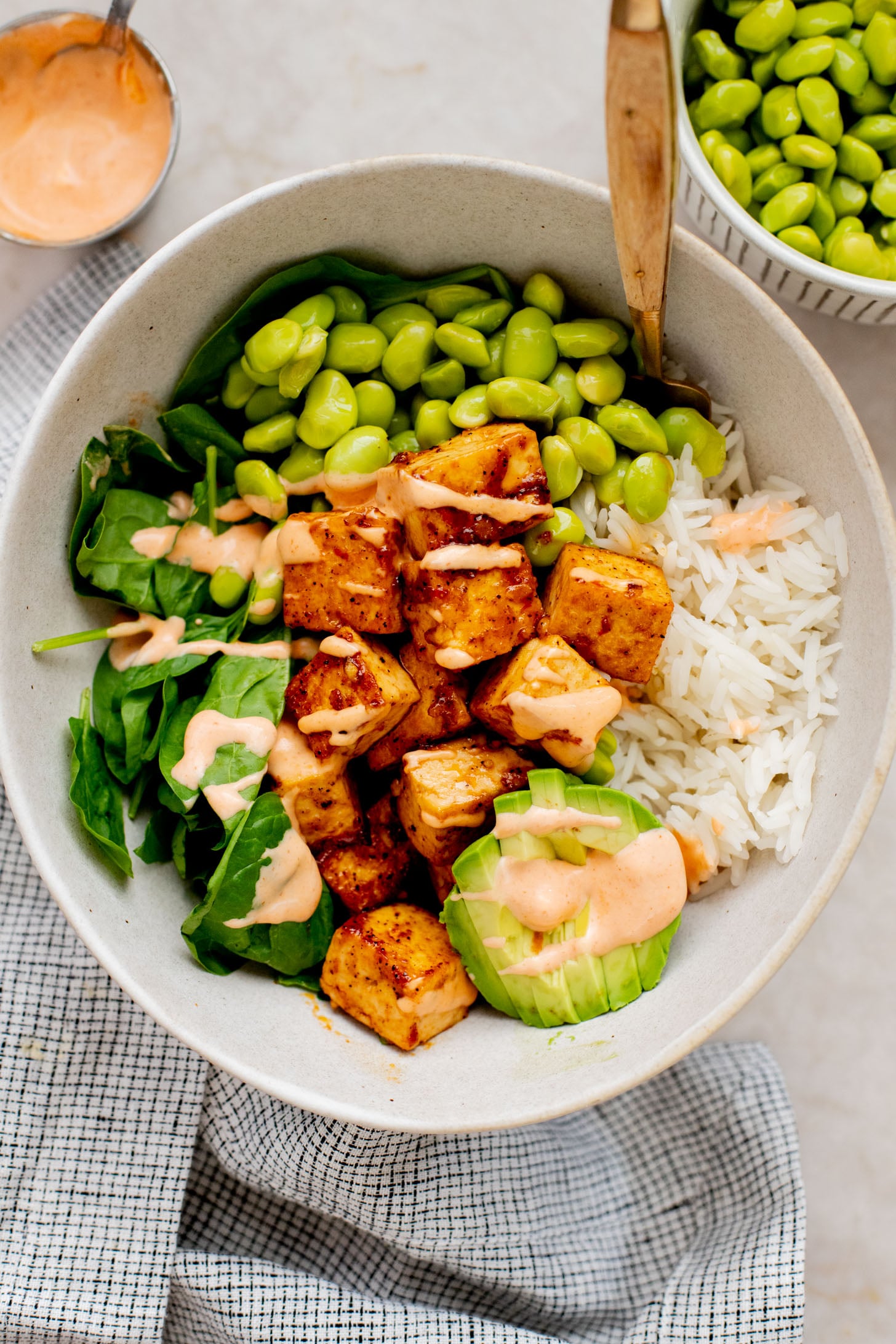 These Sweet Chili Tofu Bowls are loaded with crispy tofu, edamame, rice, avocado, greens & a spicy vegan mayo | ThisSavoryVegan.com