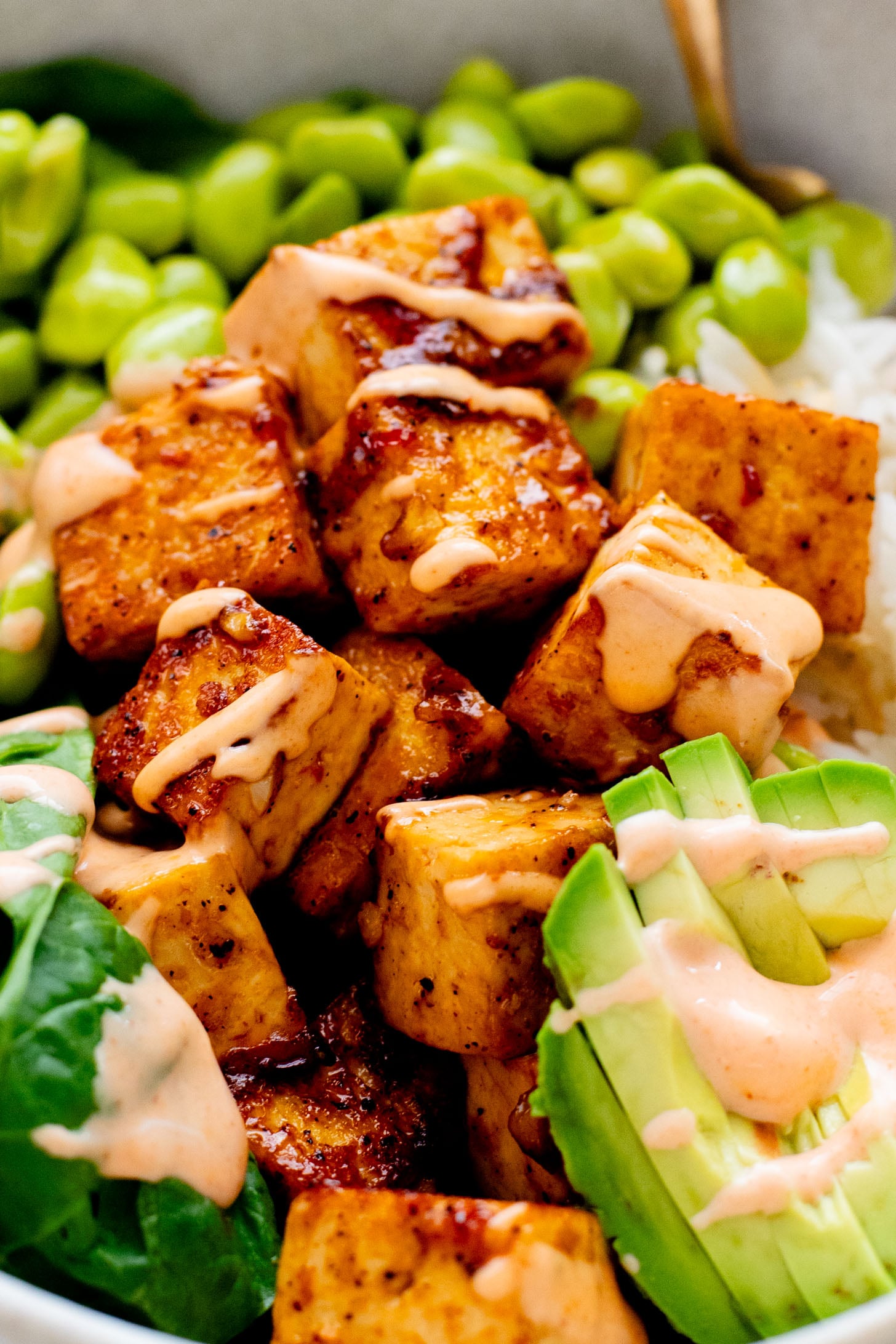 These Sweet Chili Tofu Bowls are loaded with crispy tofu, edamame, rice, avocado, greens & a spicy vegan mayo | ThisSavoryVegan.com