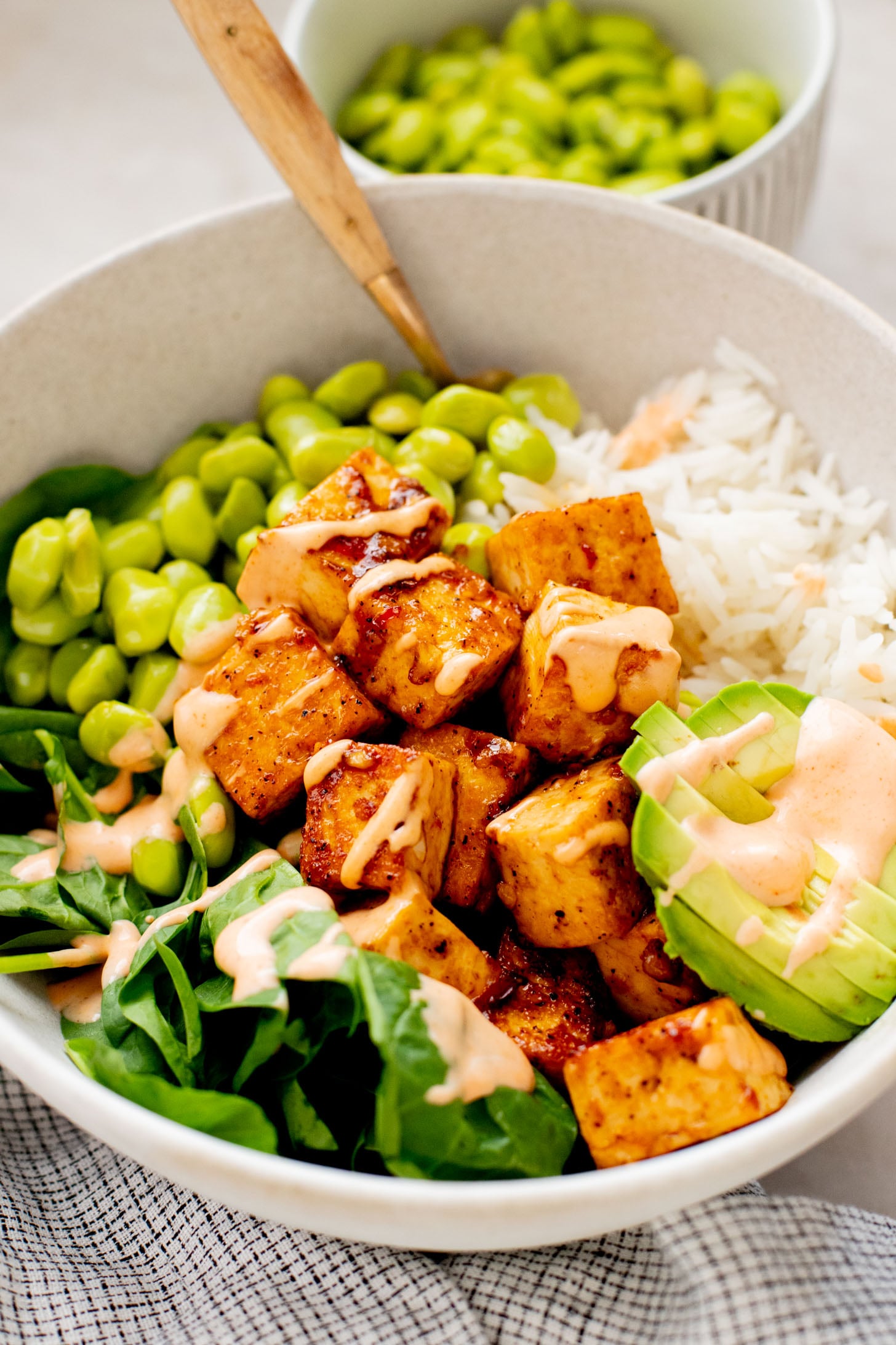 These Sweet Chili Tofu Bowls are loaded with crispy tofu, edamame, rice, avocado, greens & a spicy vegan mayo | ThisSavoryVegan.com