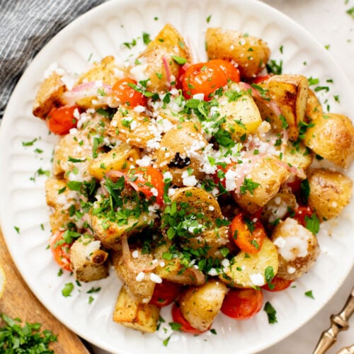 These Vegan Feta Potatoes are roasted to perfection with cherry tomatoes and topped with vegan feta, fresh herbs & lemon juice | ThisSavoryVegan.com