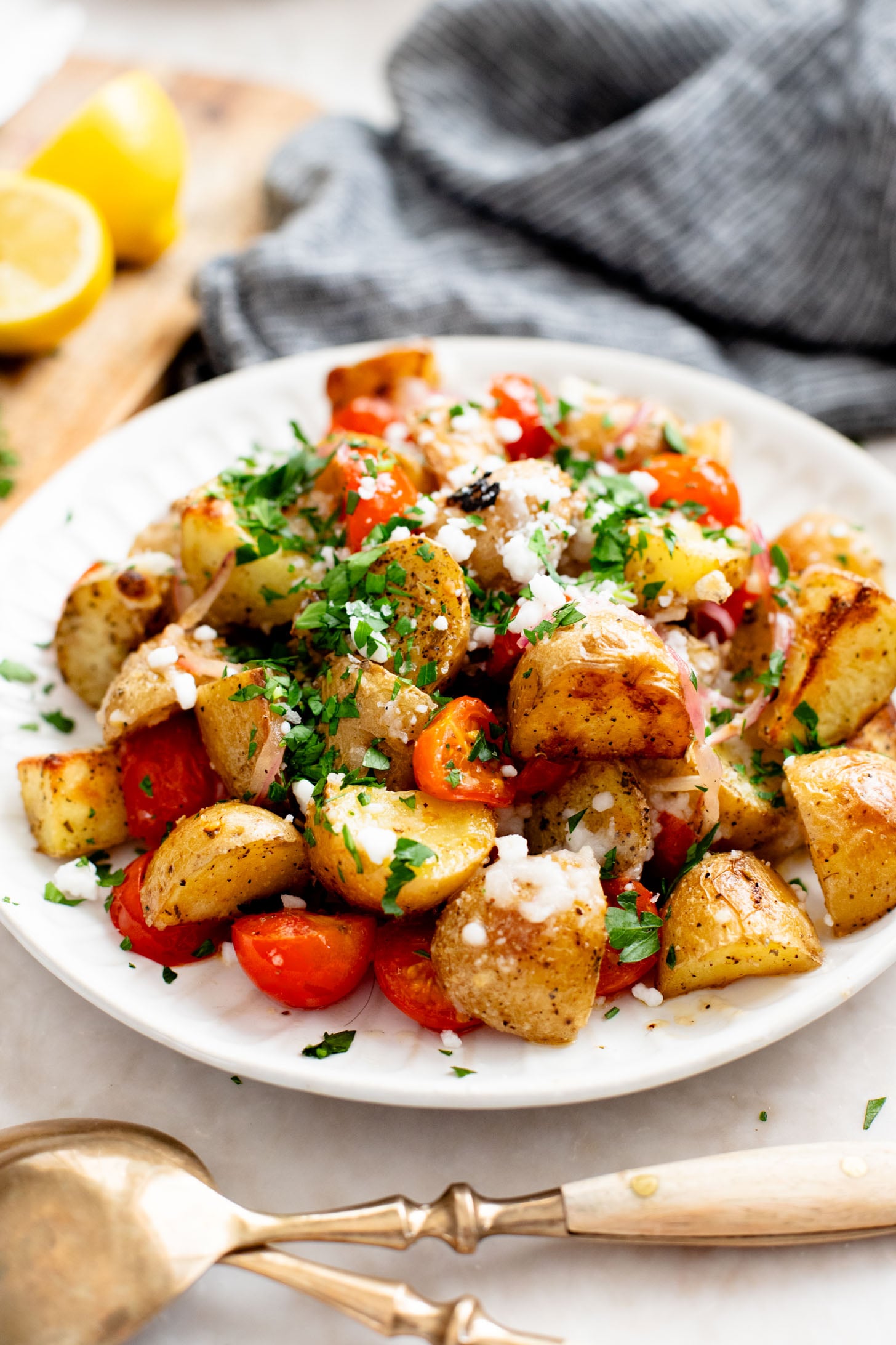 These Vegan Feta Potatoes are roasted to perfection with cherry tomatoes and topped with vegan feta, fresh herbs & lemon juice | ThisSavoryVegan.com
