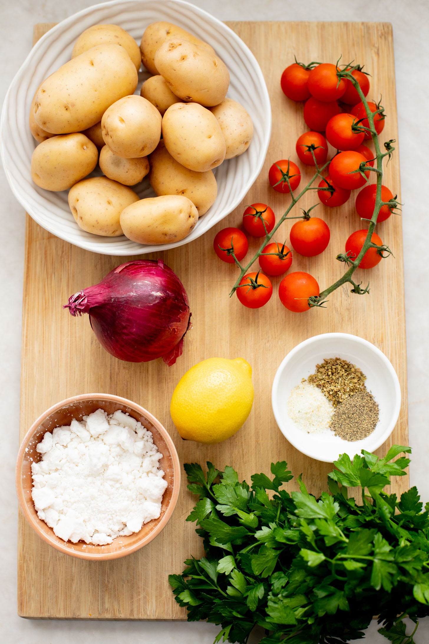 These Vegan Feta Potatoes are roasted to perfection with cherry tomatoes and topped with vegan feta, fresh herbs & lemon juice | ThisSavoryVegan.com