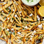 These Seasoned Fries with Feta Chive Dip is the ultimate vegan party snack. Frozen fries are seasoned and then served with the BEST vegan chive dip | ThisSavoryVegan.com