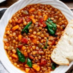 This Slow Cooker Lentil & Veggie Soup is hearty, easy and delicious. Packed with veggies & simmered all day in the most delicious vegan broth | ThisSavoryVegan.com