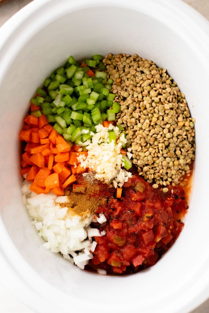 This Slow Cooker Lentil & Veggie Soup is hearty, easy and delicious. Packed with veggies & simmered all day in the most delicious vegan broth | ThisSavoryVegan.com